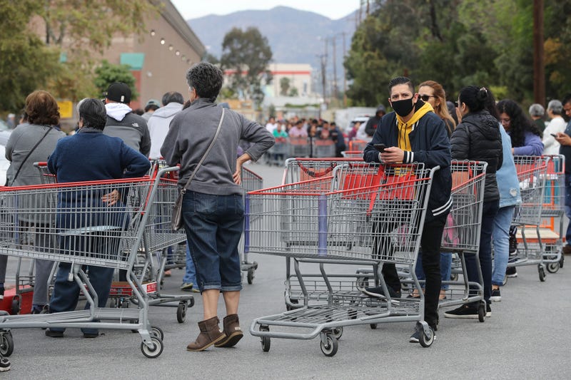 People wait in line to enter a Costco Wholesale store before it opens in the morning on March 12, 2020 in Glendale, California.
