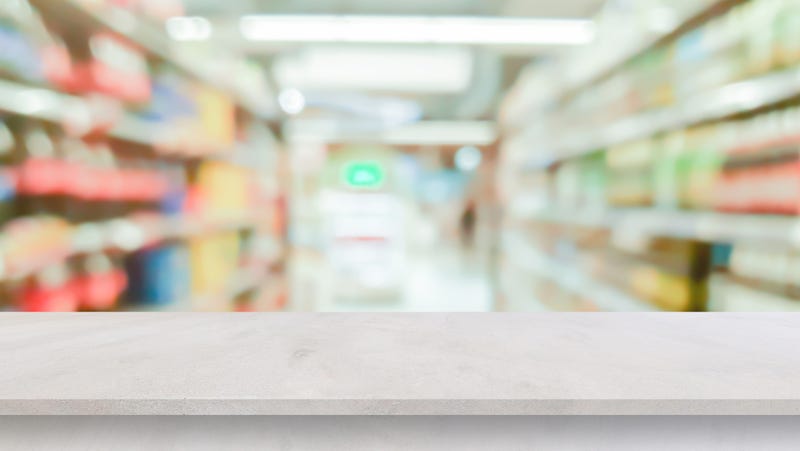 blur local supermarket convenience store background with perspective grey cement countertop to showing product or ads banner and promote marketing on display concept