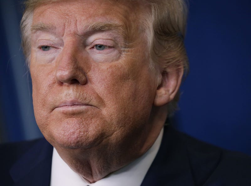 Former President Donald Trump listens to questions during a briefing.
