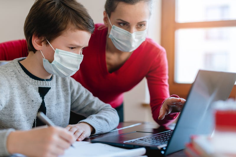 Mother and son in video chat with teacher wearing masks