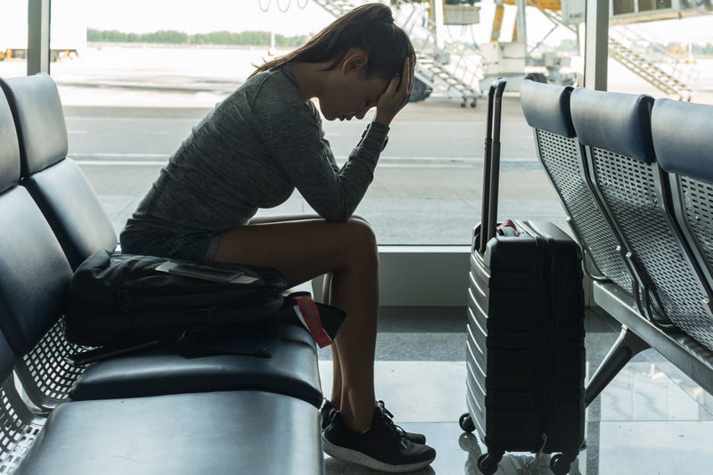 woman upset with her luggage in airport