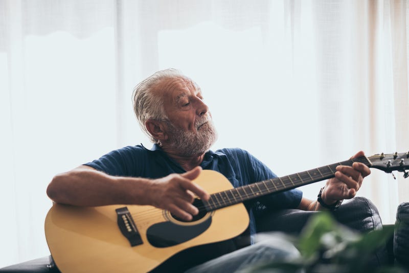 An old man playing the guitar. 