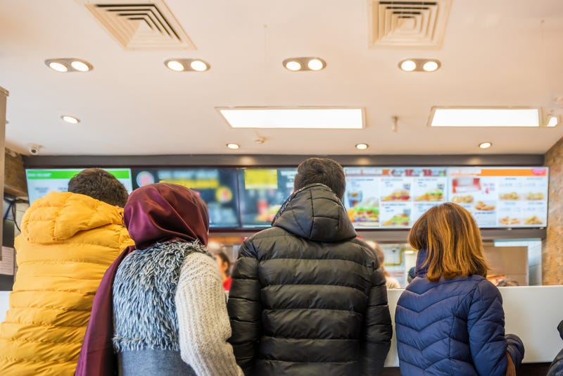 People waiting to buy food at a fast food restaurant.