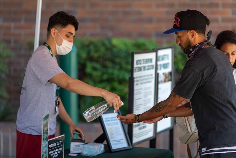 Masks and hand sanitizer are given to customers entering a Dick's Sporting Goods store as Los Angeles County retail businesses reopen while the COVID-19 pandemic continues on May 27, 2020 in Glendale, California.