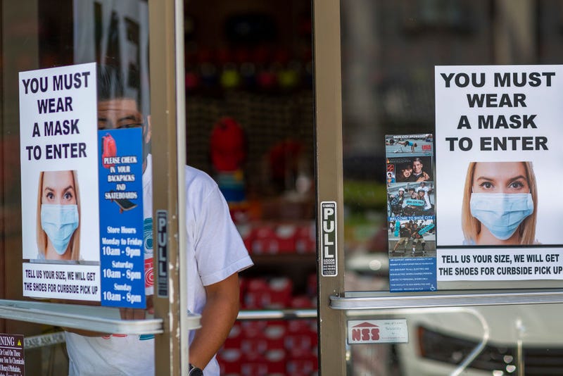A man exits a Shoe City store where masks are required for entry as Los Angeles County retail businesses reopen while the COVID-19 pandemic continues on May 27, 2020 in Glendale, California.