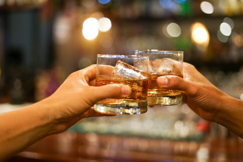 Men clinking glasses of bourbon.