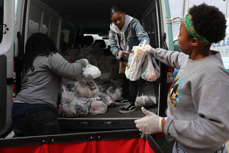 Volunteers for nonprofit organization Martha's Table Chantasia Beatty, Kiara Brown and Stephanye White load bags of fresh produce to distribute to people in underserved communities during the novel coronavirus outbreak April 01, 2020 in Washington, DC.