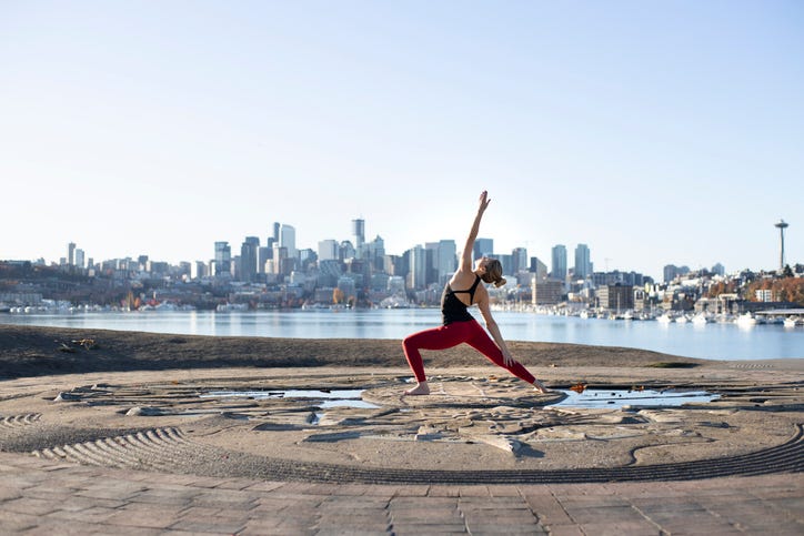 Woman practices yoga against Seattle skyline