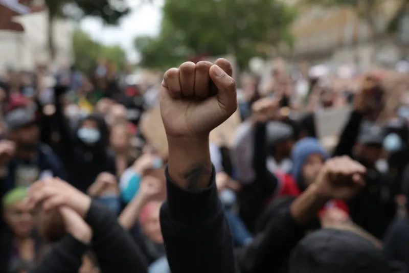 Protesters raise clenched fists during a Black Lives Matter protest outside the Houses of Parliament on June 3, 2020 in London, United Kingdom.