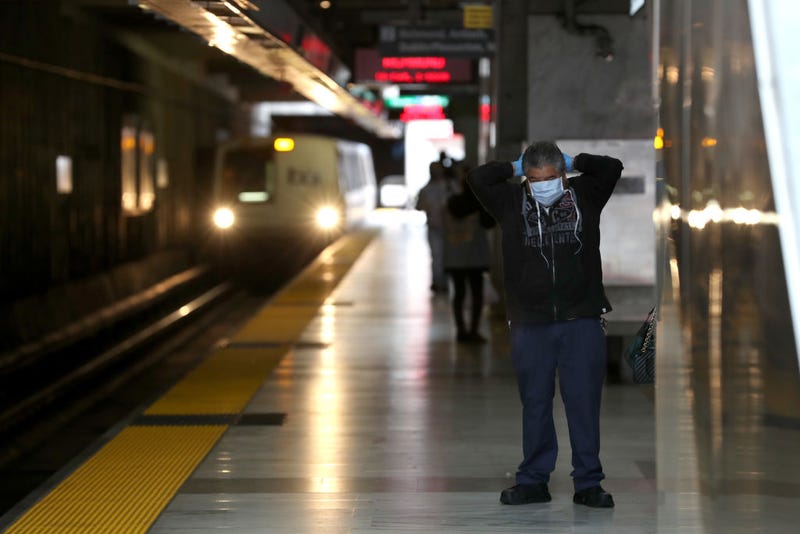 A Bay Area Rapid Transit (BART) passenger adjusts his protective mask as a train pulls into the Balboa Park station on April 08, 2020 in San Francisco, California.