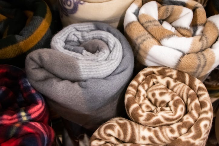 Set of fluffy soft plaid blankets rolled up.