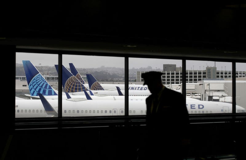 A pilot walks by United Airlines planes as they sit parked at gates at San Francisco International Airport on April 12, 2020 in San Francisco, California. 