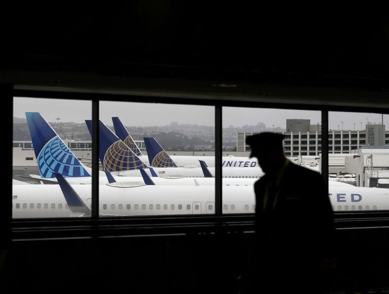 A pilot walks by United Airlines planes as they sit parked at gates at San Francisco International Airport on April 12, 2020 in San Francisco, California.
