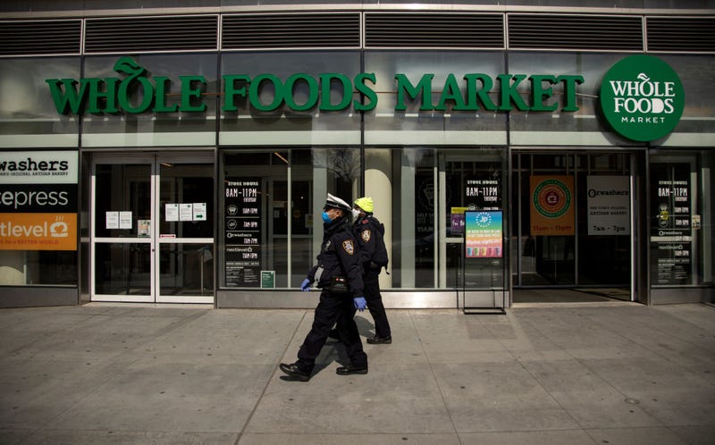 Two New York City Police Department Traffic Enforcement agents walk past the Whole Foods Market on April 14, 2020 in the Brooklyn borough of New York City.