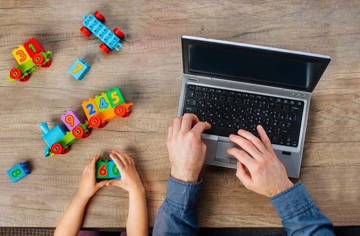 Child Playing And Adult Working