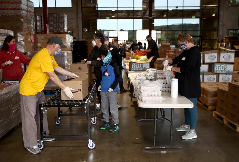 Volunteers pack boxes full of food at the San Francisco-Marin Food Bank on April 18, 2020 in San Rafael, California.