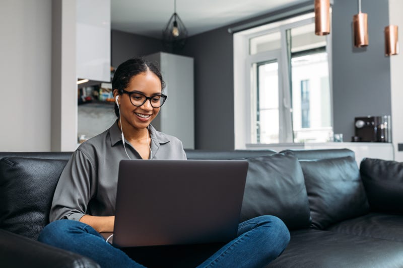 woman working on laptop on couch at home