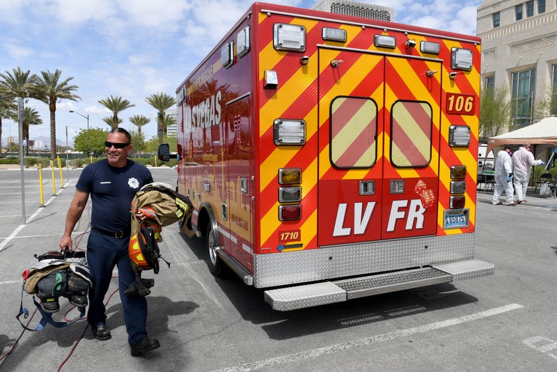 Las Vegas Fire & Rescue firefighter/paramedic Ricardo Vidal carries gear back to his ambulance after it was sanitized amid the coronavirus pandemic