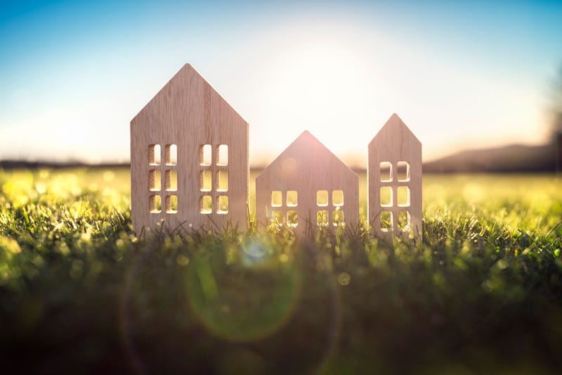 mini wooden cutout houses on a patch of grass
