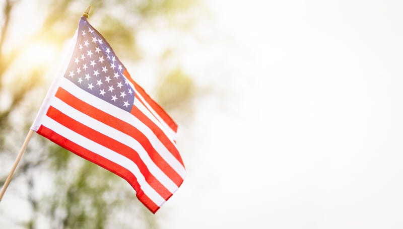 An American flag hangs from a home to honor America's Independence Day