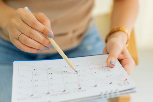 woman marking date on calendar