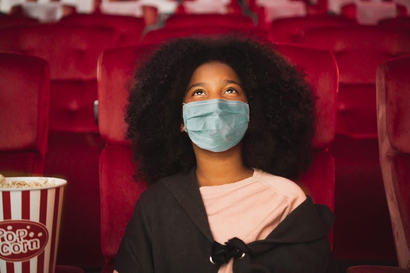 Moviegoer wearing a mask while watching a movie at movie theater