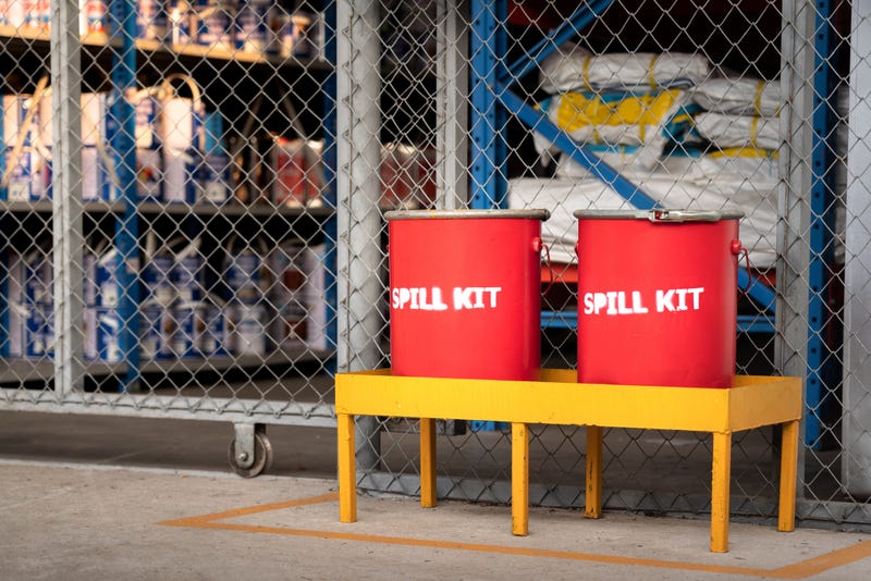 Spill kit containment boxes are prepared and placed in front of the chemical storage room.