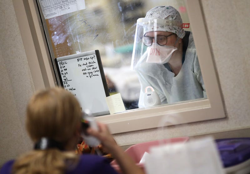A nurse communicates with a colleague through a window while treating a patient with coronavirus in the intensive care unit at a hospital on May 1, 2020 in Leonardtown, Maryland.