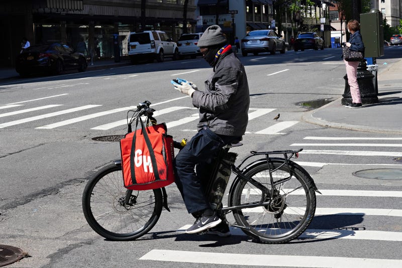 A Grubhub delivery person checks his phone in New York City.