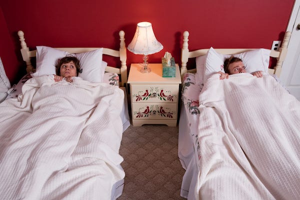 Couple sleeping in separate beds