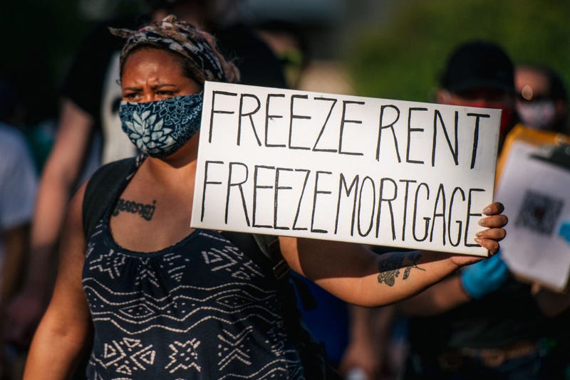 A woman holds a sign up as demonstrators march in the street during the Cancel Rent and Mortgages rally on June 30, 2020 in Minneapolis, Minnesota. The Los Angeles City Council announced that it's handing the city's rental assistance program to the state, which should result in faster processing of applications from struggling Angelenos that need additional rental assistance during the pandemic.