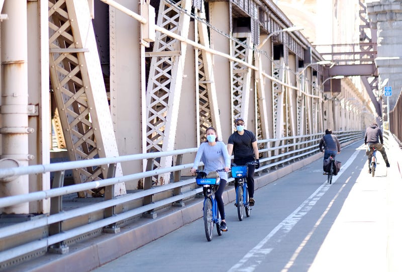 Cyclists wearing masks ride on the Queensboro Bridge as the coronavirus continues to spread across the United States on on May 13, 2020 in New York City.