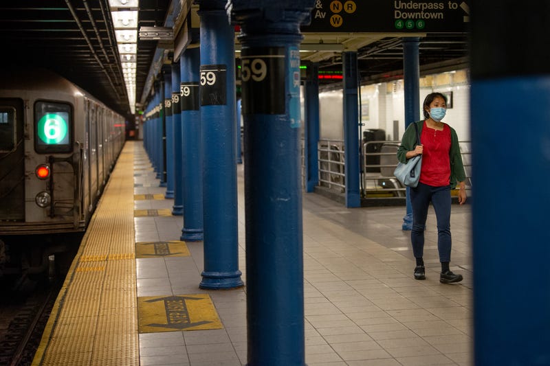A woman walks on a platform at the Lexington Avenue/59th Street station