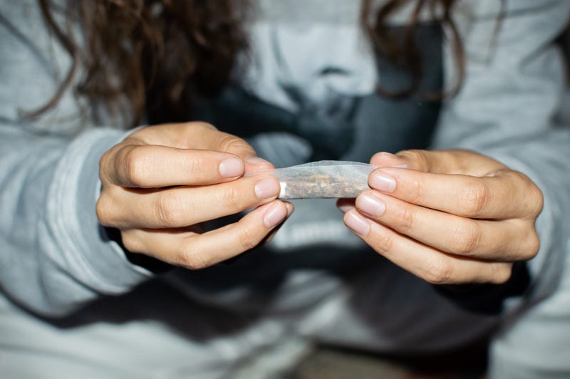 Woman rolling a cannabis joint. 