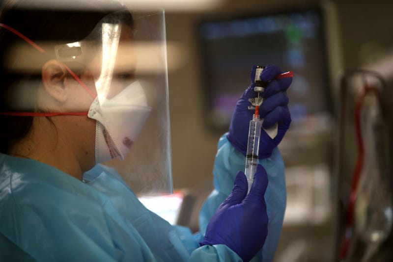A nurse prepares medication as she cares for a coronavirus COVID-19 patient