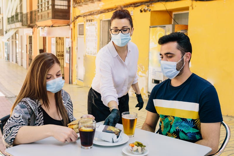 Masked restaurant patrons and waitress