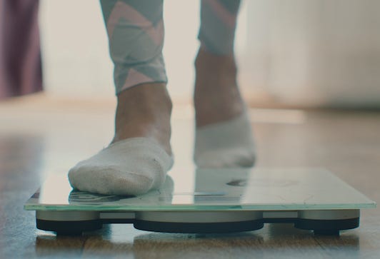 Woman stepping on scale