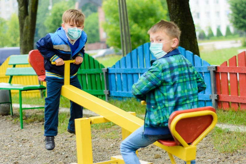 Children wearing face masks in a park.