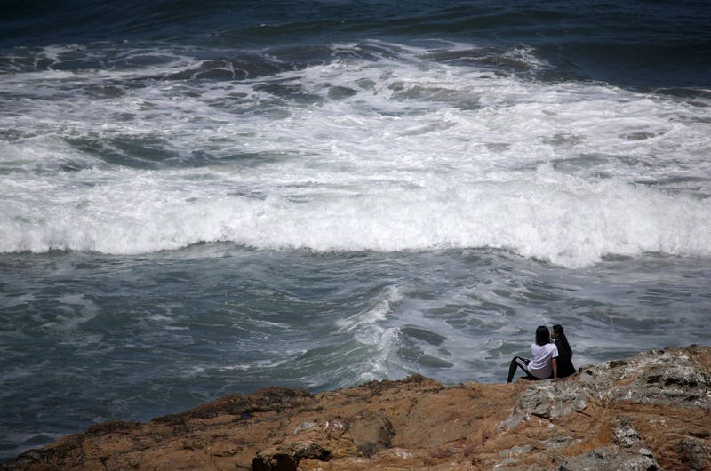 A couple sits on a rock overlooking Ocean Beach on May 26, 2020 in San Francisco, California.