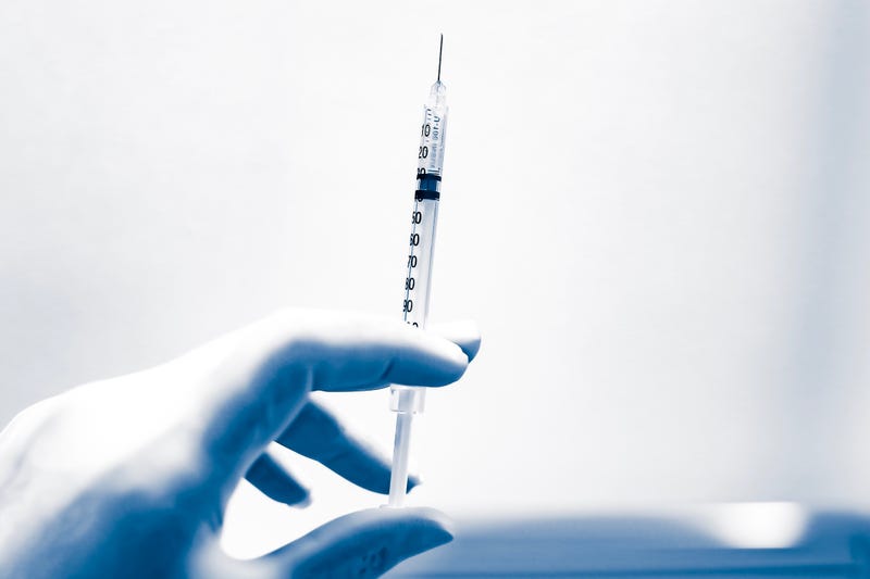 Syringe in gloved hand stock photo.