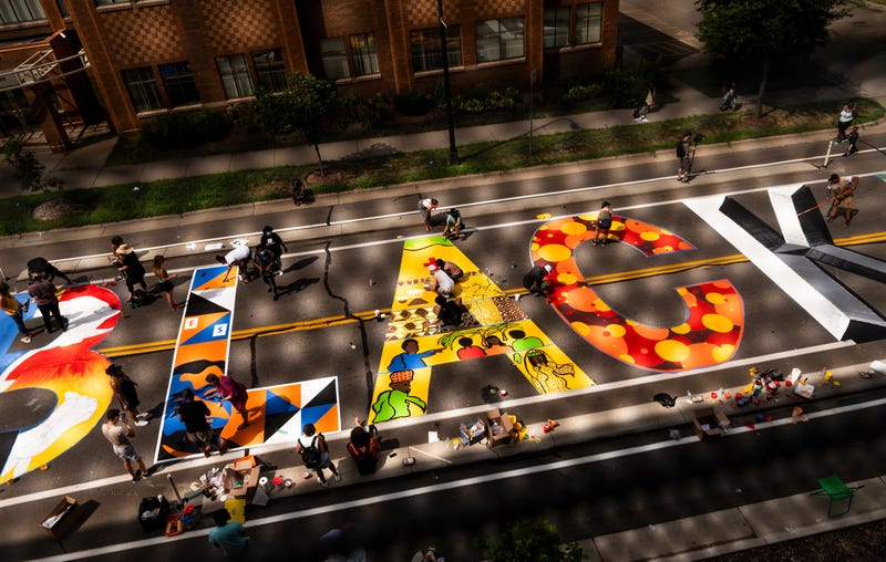 A group of artists and volunteers paint a Black Lives Matter mural on the street outside the Minnesota African American Heritage Museum and Gallery on July 18, 2020 in Minneapolis, Minnesota. The mural will be painted by 16 artists, who will each create their own individual artwork on a letter.