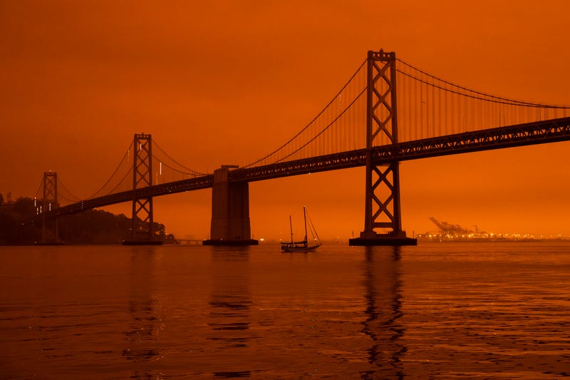 SAN FRANCISCO, CA - SEPTEMBER 09: A ship passes beneath the Bay Bridge as smoke from various wildfires burning across Northern California mixes with the marine layer, blanketing San Francisco in darkness and an orange glow on September 9, 2020 in San Francisco, California. Over 2 million acres have burned this year as wildfires continue to burn across the state.
