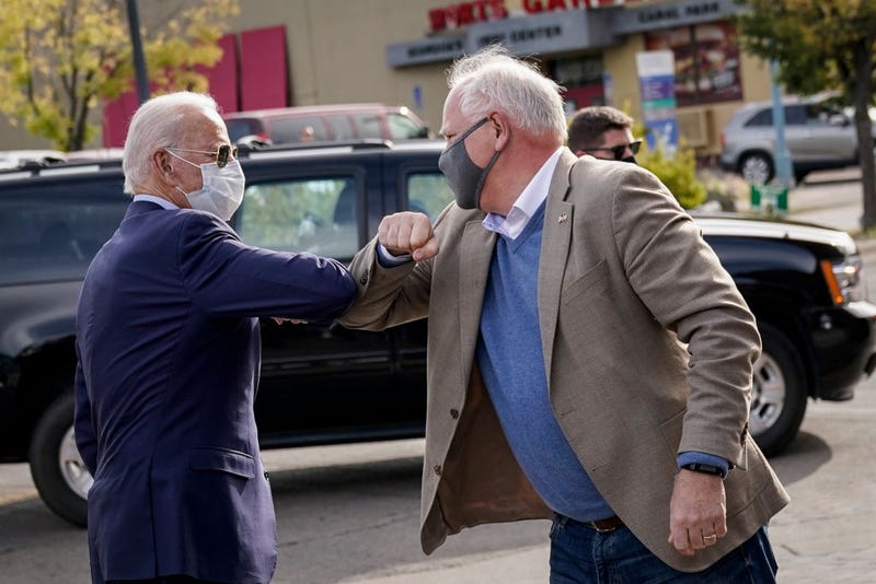 At the time, Democratic presidential nominee and former Vice President Joe Biden bumps elbows with Minnesota Governor Tim Walz in 2020 in Duluth, Minnesota. 