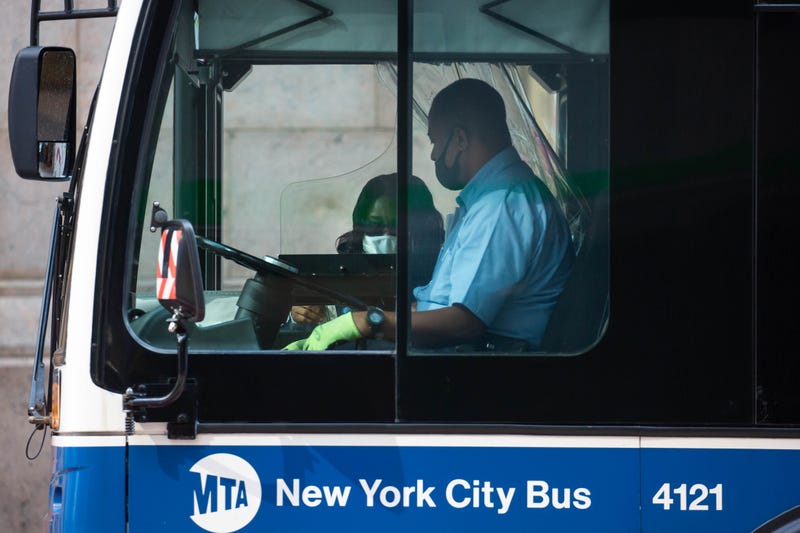 A person wearing a protective mask boards a bus in New York, U.S., on Monday, Sept. 21, 2020.