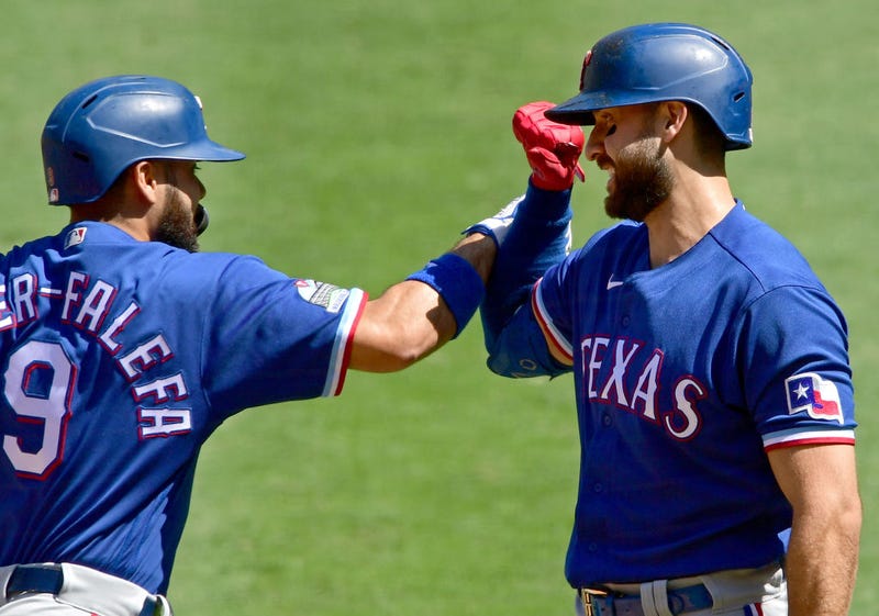 Isiah Kiner-Falefa #9 of the Texas Rangers is congratulated by Joey Gallo #13 after hitting a solo home run in the first inning against the Los Angeles Angels at Angel Stadium of Anaheim on September 21, 2020.
