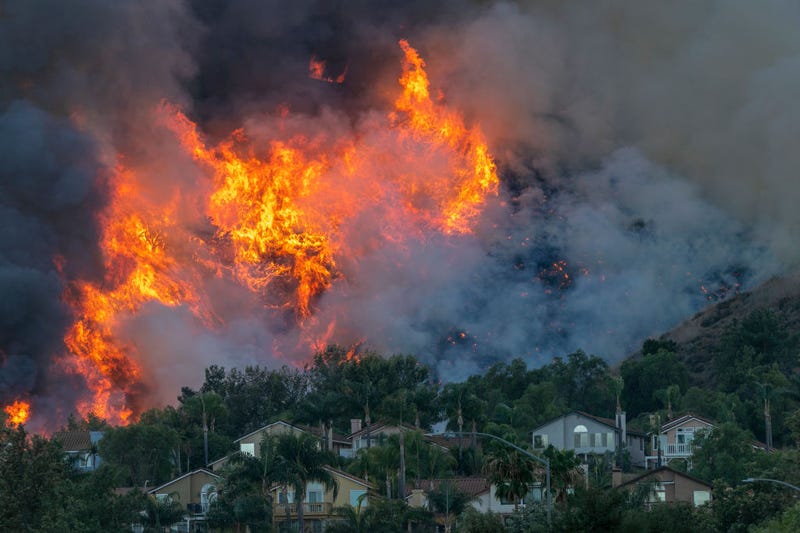 Flames rise near homes during the Blue Ridge Fire on October 27, 2020 in Chino Hills, California.