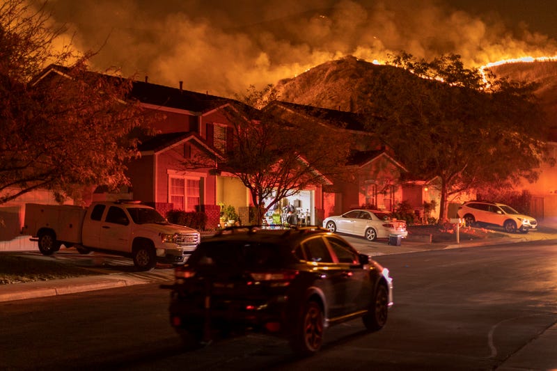 wildfire burning behind residential street