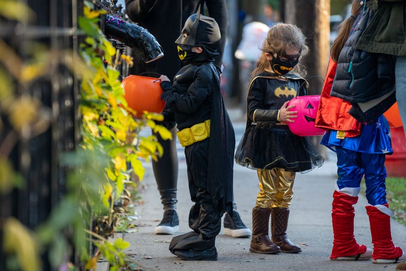 Children receive treats by candy chutes while trick-or-treating for Halloween in Woodlawn Heights on October 31, 2020 in New York City.