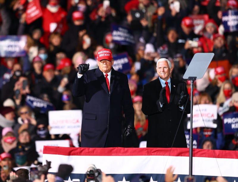 U.S. President Donald Trump (L) and U.S. Vice President Mike Pence (R) greet supporters at a rally on November 2, 2020 in Traverse City, Michigan.