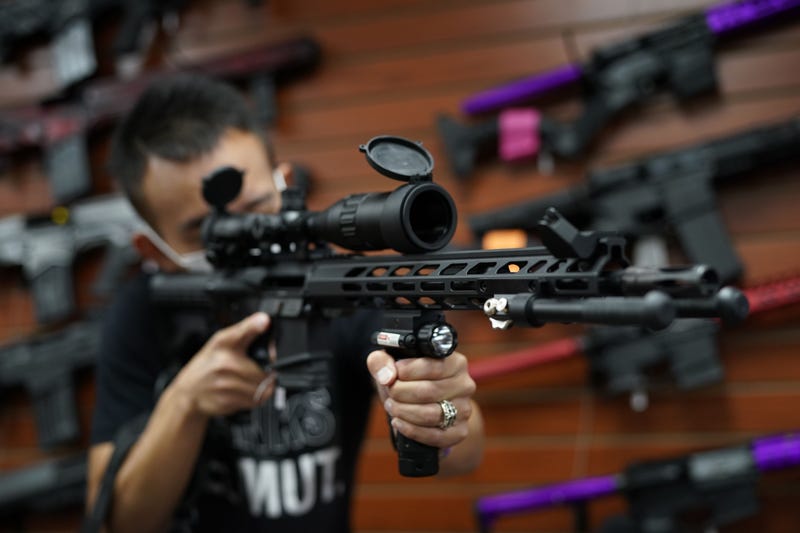 Tom Cai shows off a long gun at Jimmy's Sport Shop in Mineola, New York on September 25, 2020.